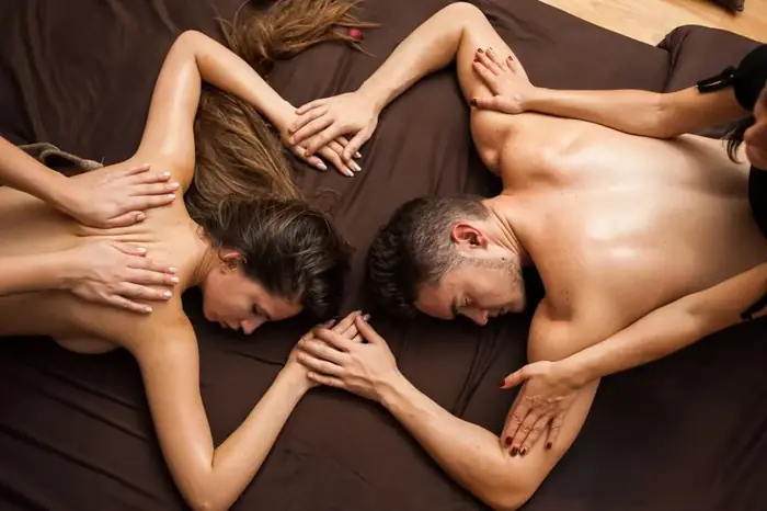 Two therapists giving a couple a four hands massage